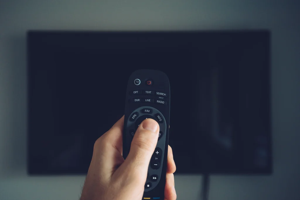 man hand holding tv remote