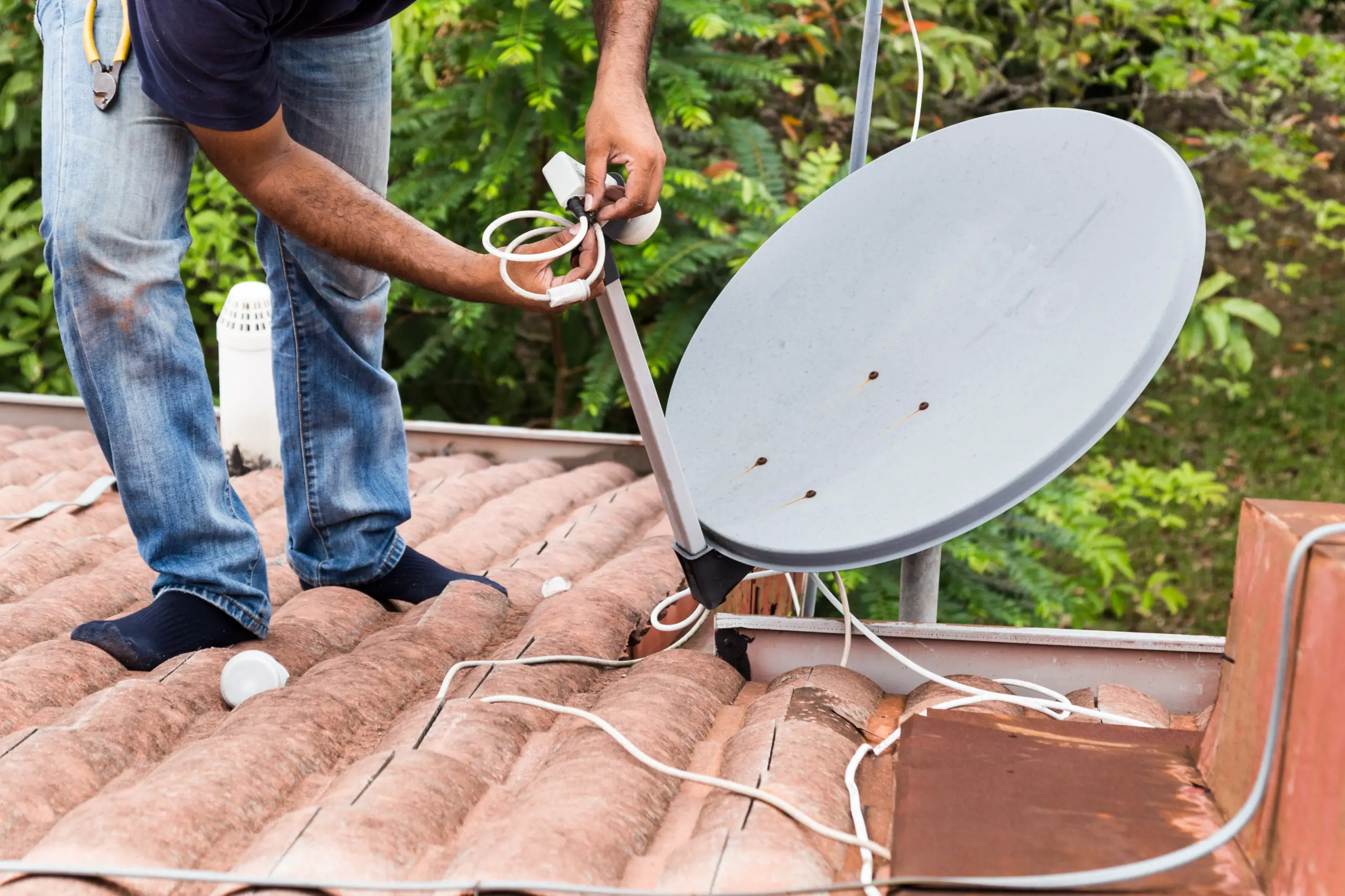 Worker installing satellite dish and antenna on roof top - https://elements.envato.com/worker-installing-satellite-dish-and-antenna - https://elements.envato.com/worker-installing-satellite-dish-and-antenna-on-ro-P64UPCM