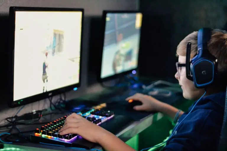 boy playing video game on pc wearing headset