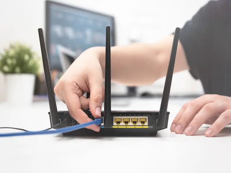 woman plugging wire into router