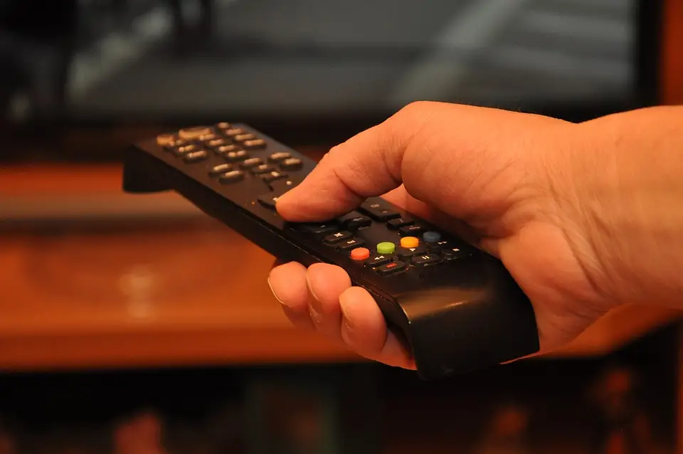 male hand holding tv remote