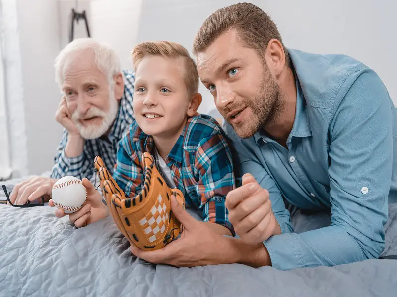 grandfather, son and dad watching baseball game together 