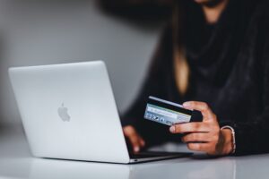 woman with MacBook and debit card