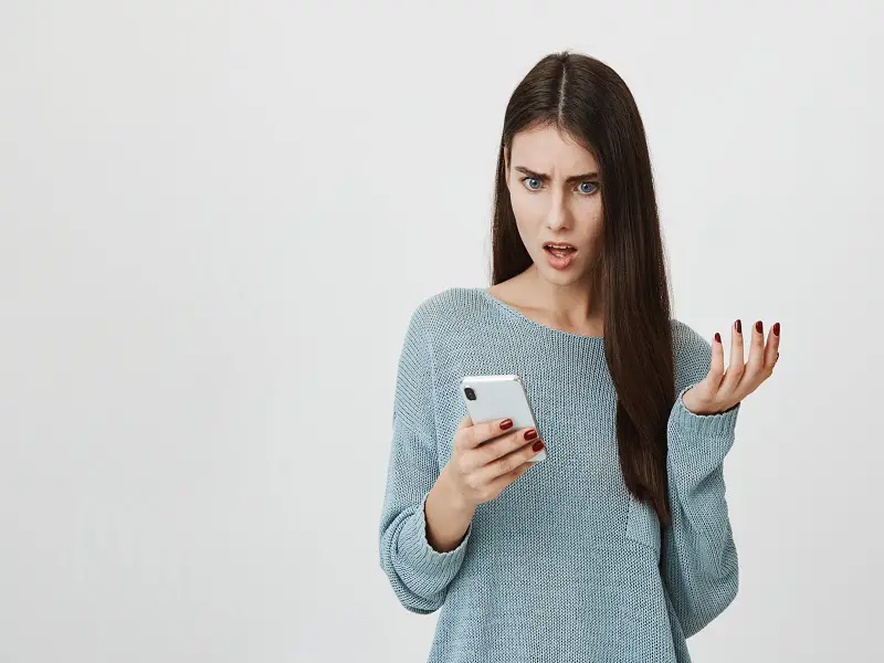 woman looking at mobile phone shocked