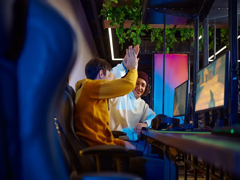 teenage boys high-fiving while playing video game